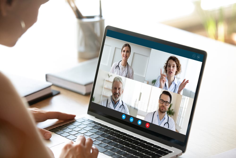 Person attending a live medical webinar on laptop