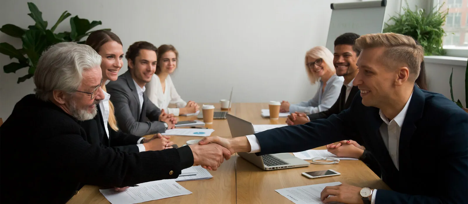 Senior Investor Buying Startup Handshaking Young Entrepreneur in Group Meeting